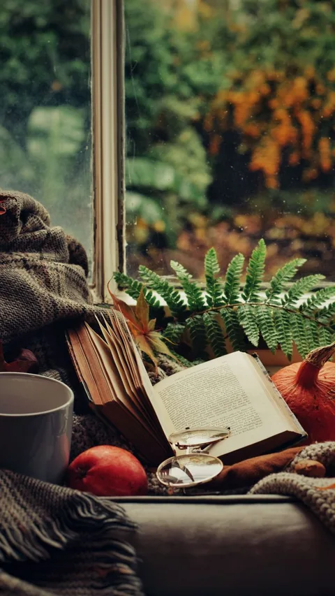 Деревянный подоконник с книгами, пледом и кружкой чая